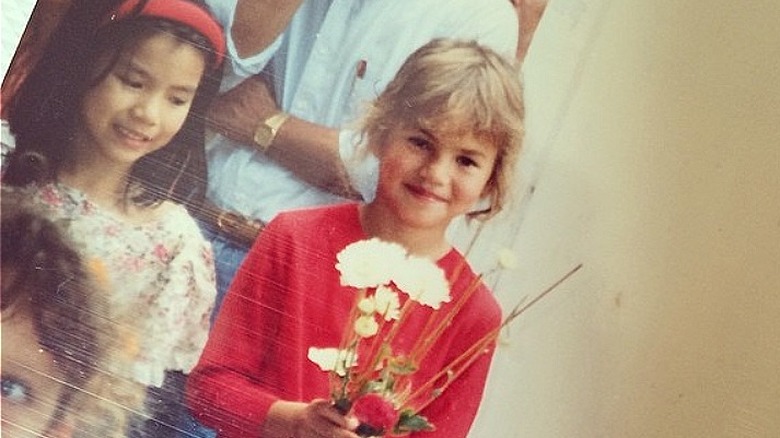 Chrissy Teigen as a child holding flowers