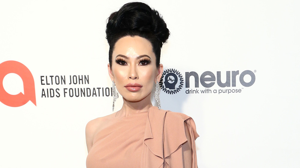 Christine Chiu posing on the red carpet in long earrings and an updo