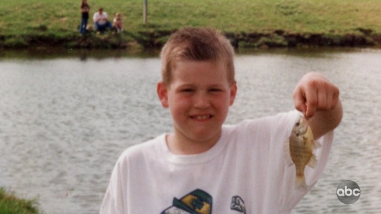 Colton Underwood in a photo as a young boy holding a fish 