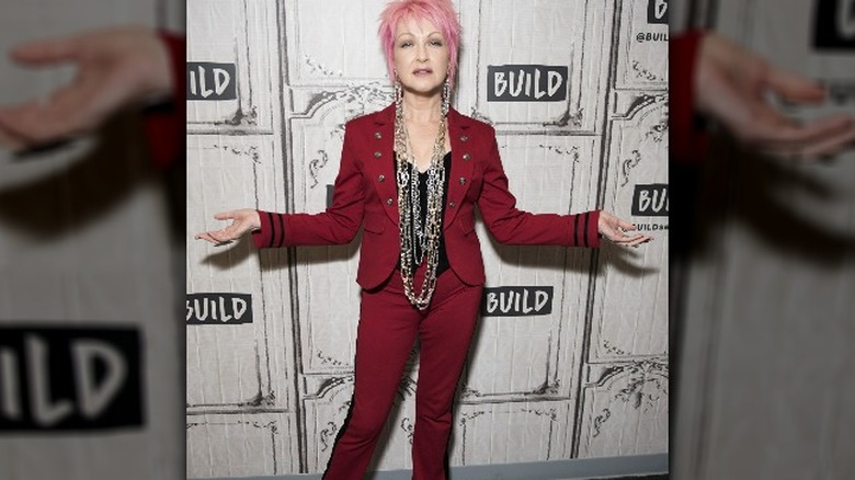 Cyndi Lauper in pink hair and red suit