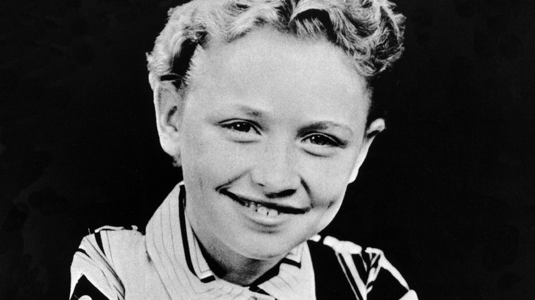 Dolly Parton smiles for the camera as a child