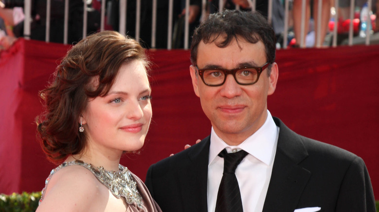 Elisabeth Moss and Fred Armisen posing on red carpet with slight smiles