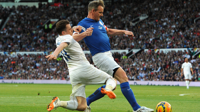 Danny Jones of England tackles Gordon Ramsay of the Rest of the World during Soccer Aid 2014 