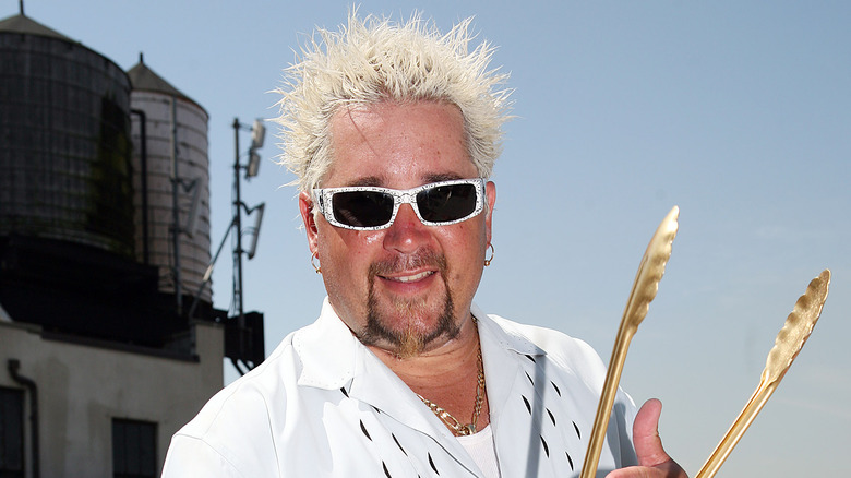 Guy Fieri holding tongs