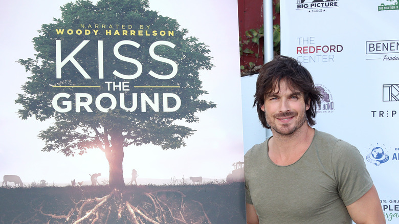 Ian Somerhalder poses next to a 'Kiss the Ground' poster.