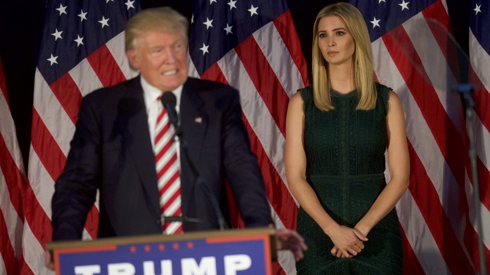 Ivanka Trump in a green dress, watching Donald Trump give a campaign speech