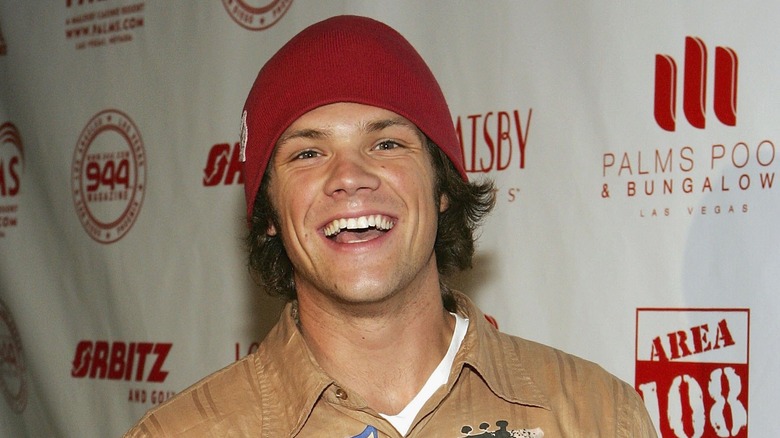 Jared Padalecki poses in a red beanie