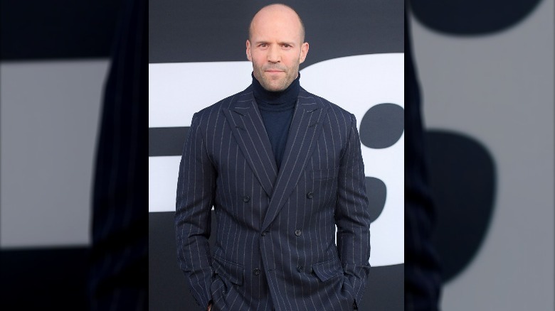 Jason Statham in a pinstripe suit and turtleneck