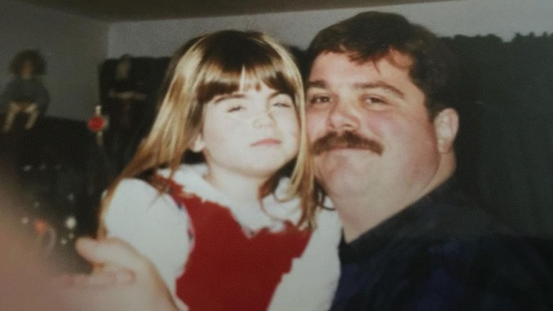 Young Joanna "JoJo" Levesque in a white shirt and red dress with her father