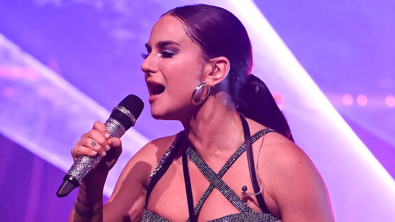 Joanna "JoJo" Levesque wearing a strappy sparkly outfit while singing into a microphone