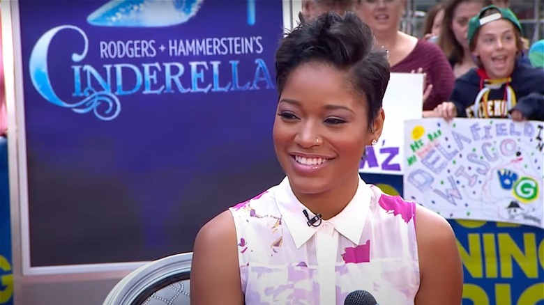 Keke Palmer in front of a Cinderella poster, smiling