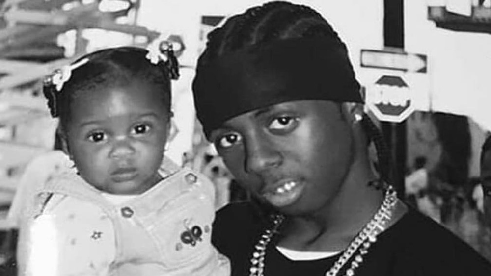 Lil Wayne holding daughter Reginae Carter as a baby