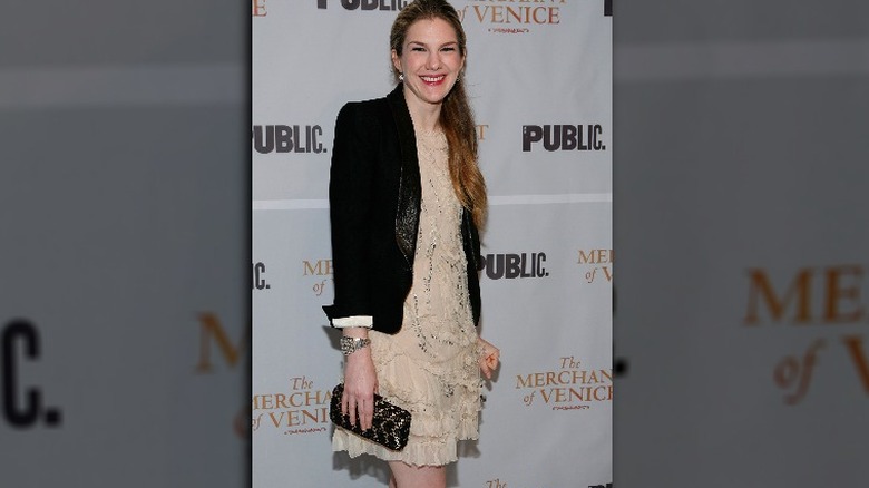 lily rabe smiling in a blazer and dress