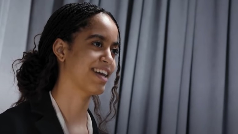 Malia Obama talking with her hair pulled back