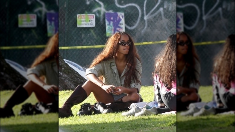 Malia Obama sitting in grass