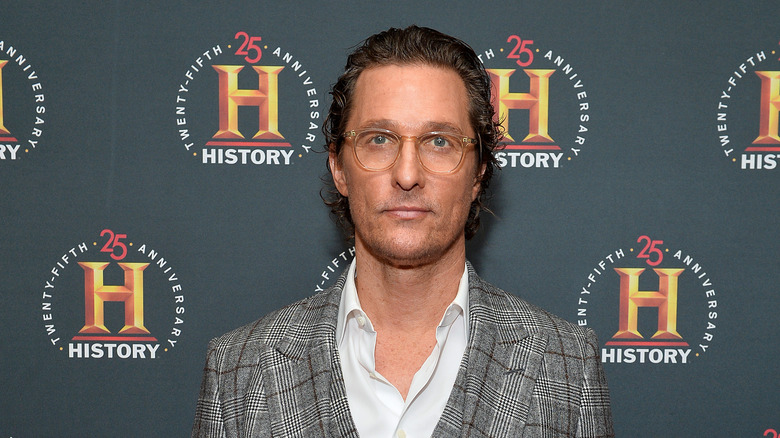 Matthew McConaughey poses in suit and glasses