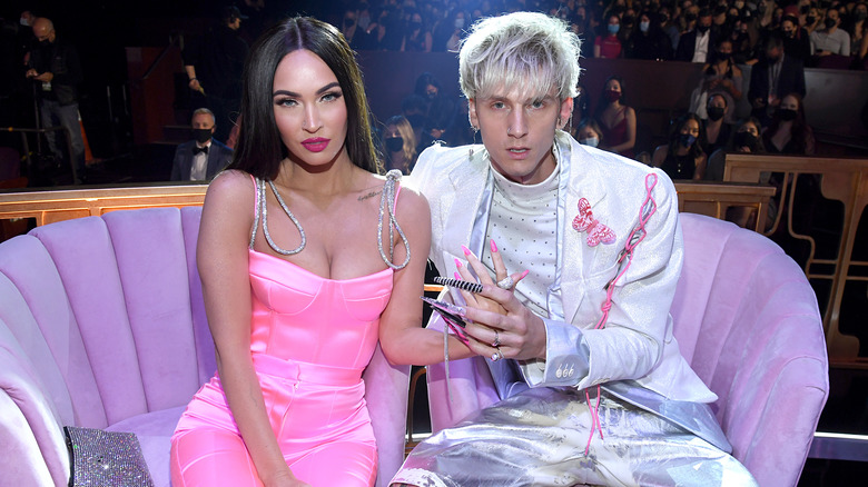 Megan Fox sitting and holding hands with Machine Gun Kelly