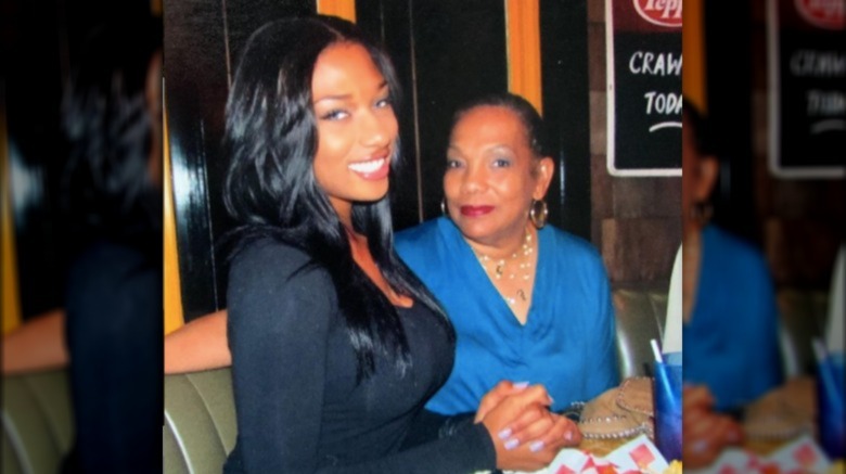 Megan Thee Stallion as a junior in high school, posing for a picture with her grandmother