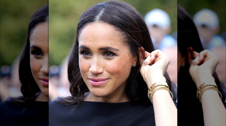 Meghan Markle fixing her hair