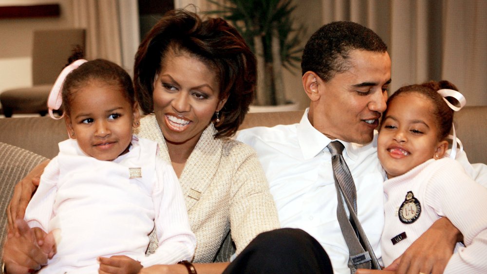 Sasha Obama, Michelle Obama, Barack Obama, and Malia Obama posing for a family photo at a hotel room in Chicago in 2004 