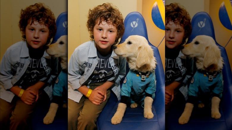 Nolan Gould sits beside puppy