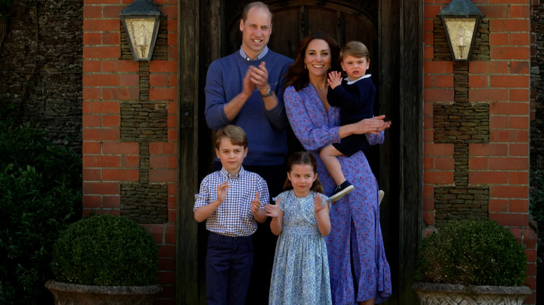 The Wales family clapping outside