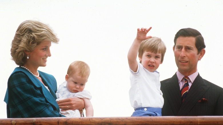 Princess Diana, Prince Charles, and young Prince William and Harry stand on a boat