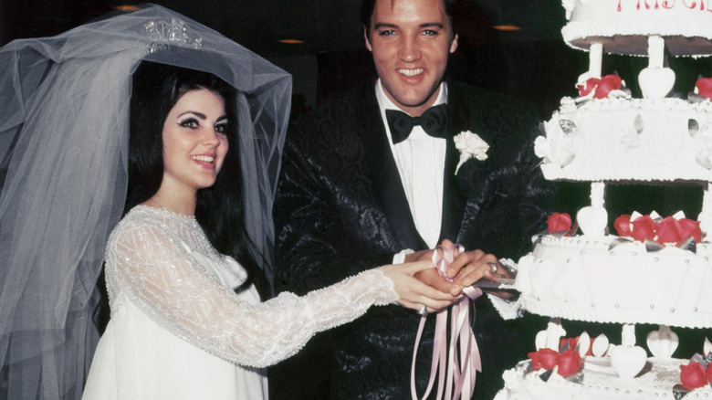 Priscilla and Elvis Presley cutting wedding cake