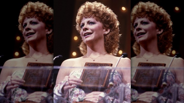 Reba McEntire accepting award, smiling on stage