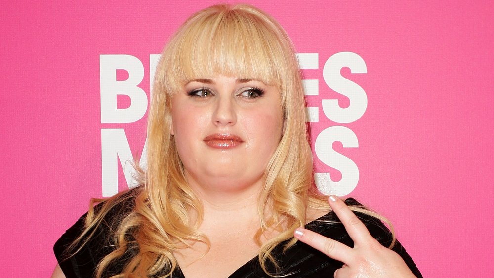 Rebel Wilson flashing a peace sign at the Bridesmaids premiere