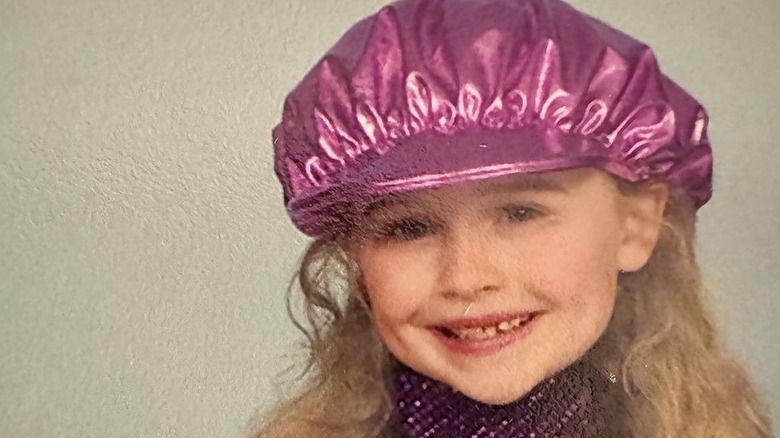 Sabrina Carpenter as a child wearing a pink satin hat and purple sparkling leotard