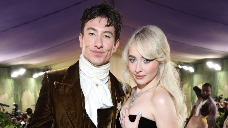 Barry Keoghan in a brown jacket and white frilled collar with Sabrina Carpenter in a jeweled strapless gown