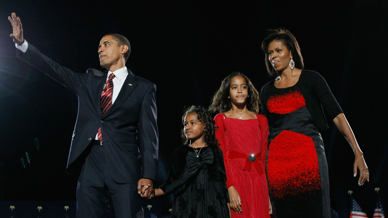 Barack Obama waving to the crowd alongside family