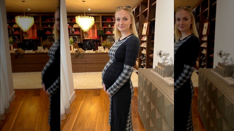 Sophie Turner cradling baby bump