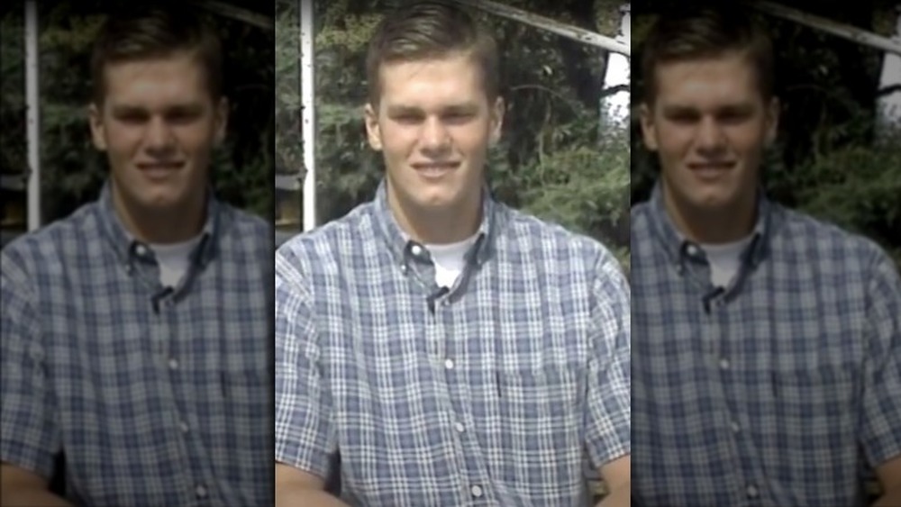 A teenage Tom Brady smiling during an interview 