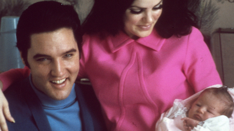 Elvis and Priscilla Presley, holding baby Lisa Marie