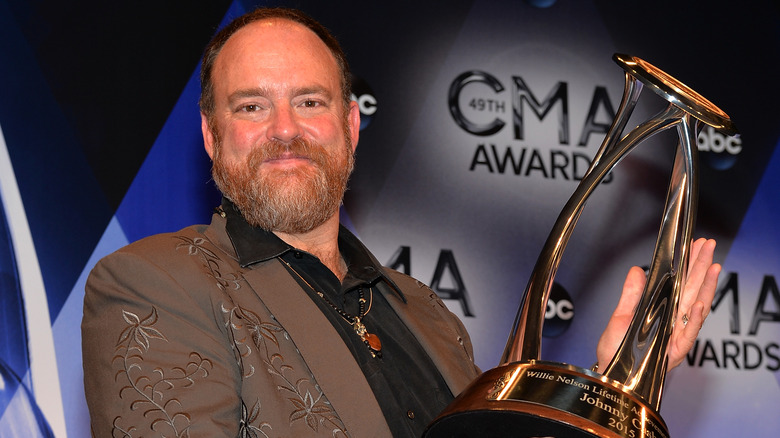 John Carter Cash holding CMA Award