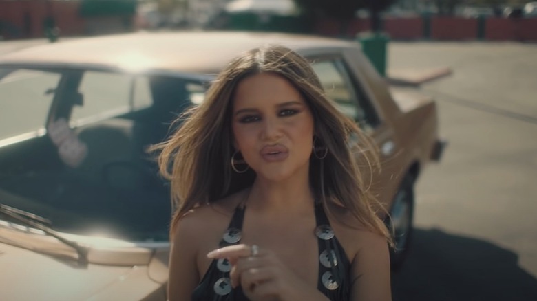 Maren Morris standing by a car