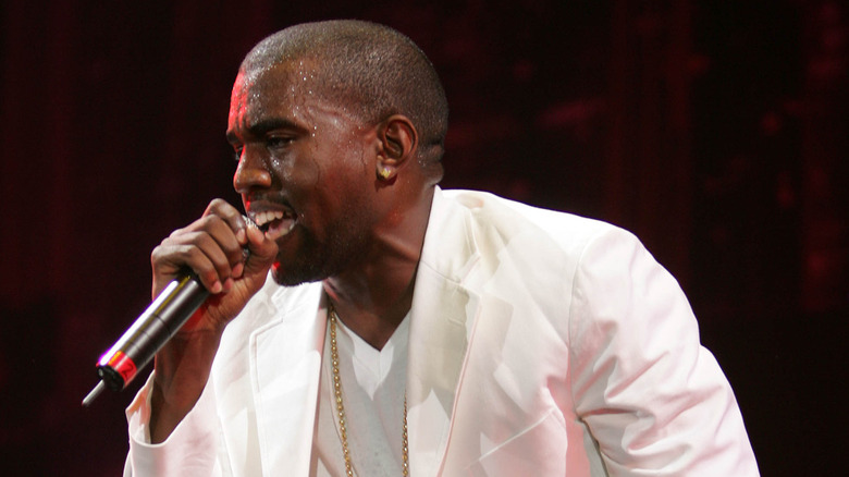 Kanye West performs on stage wearing an all white outfit