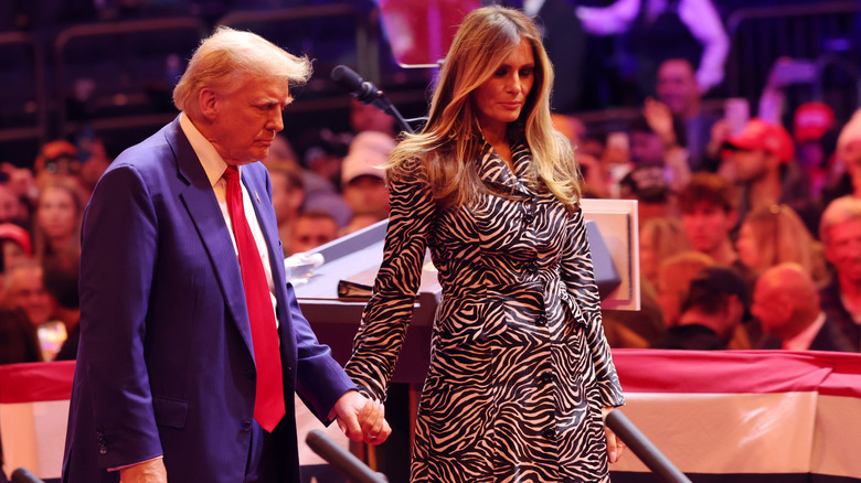 Melania Trump wearing a zebra-print coat and holding Donald Trump's hand at his Madison Square Garden rally