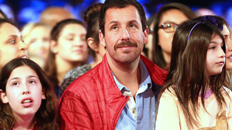 Adam Sandler with his daughters, seated