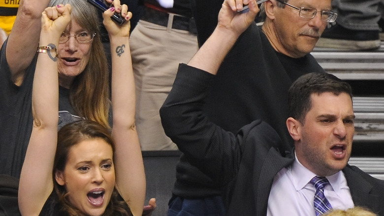 Alyssa Milano and her husband David Bugliari cheering at a basketball game