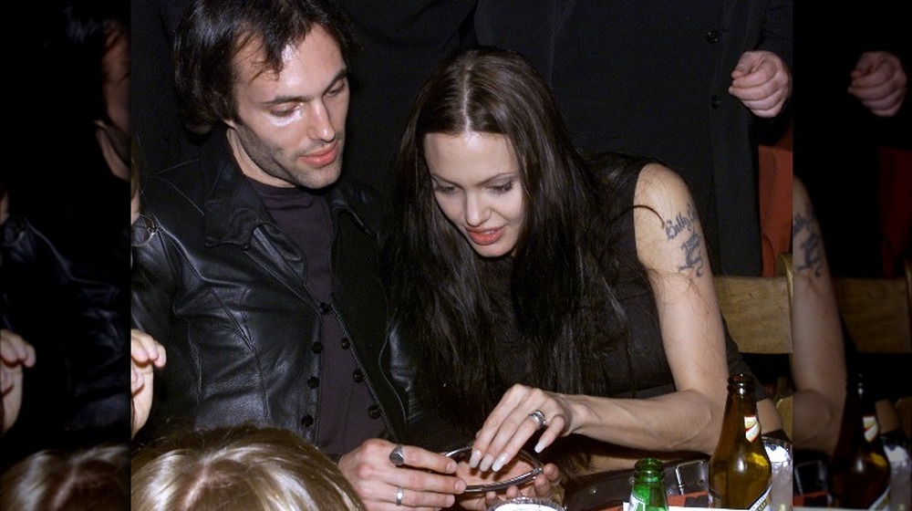 Angelina Jolie takes a look at James Haven's sunglasses in 2001