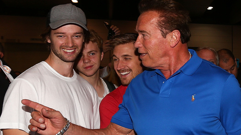 Patrick Schwarzenegger smiling with dad Arnold Schwarzenegger