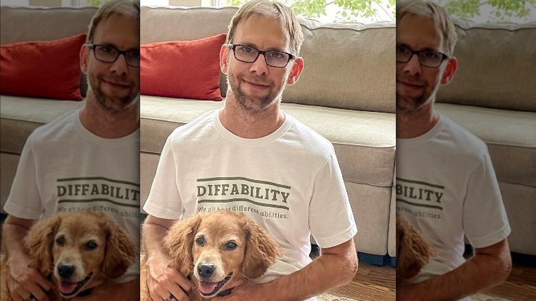 Michael Kutcher smiling with his dog