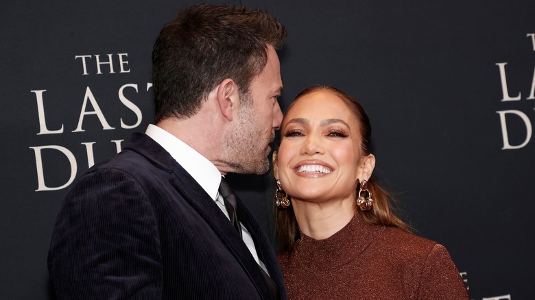 Ben Affleck with mouth near Jennifer Lopez's ear