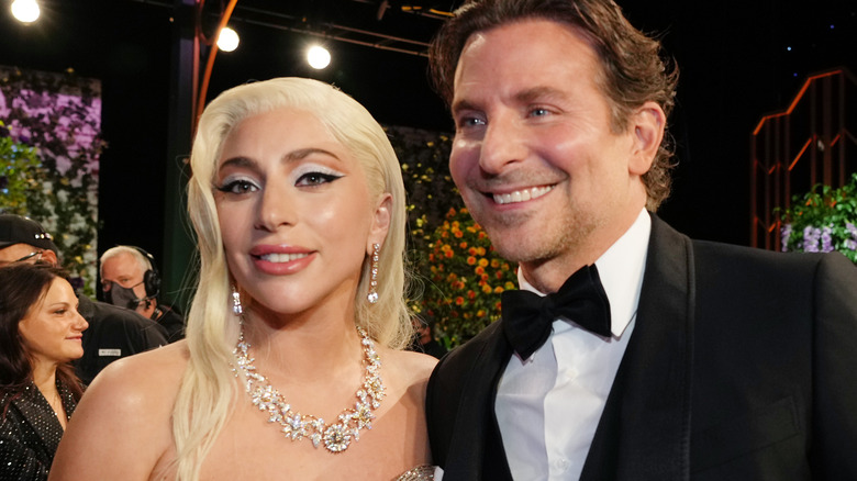 Lady Gaga and Bradley Cooper smile at an awards ceremony