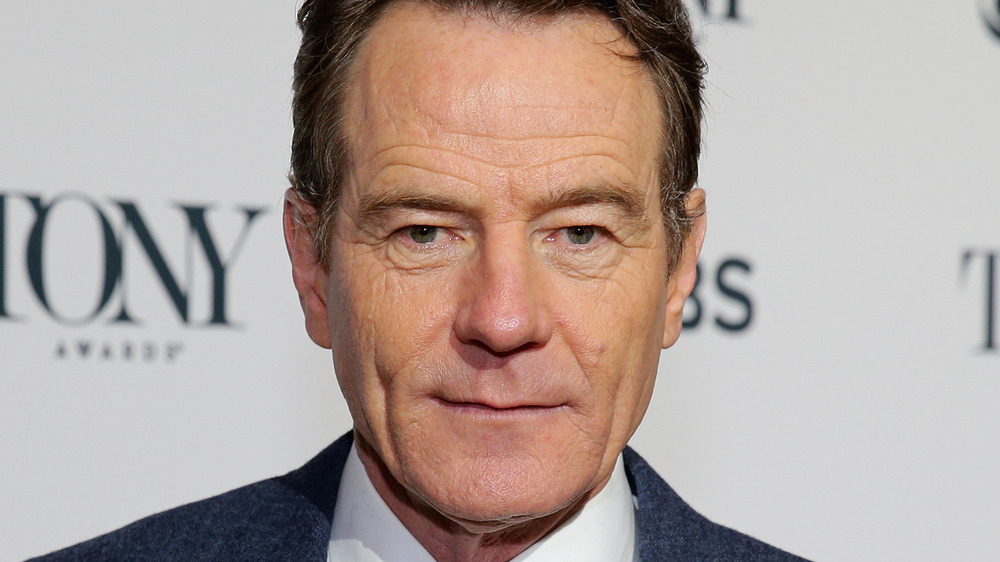 Bryan Cranston poses in a navy suit.