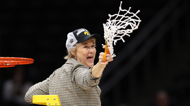 Lisa Bluder holding basketball net 