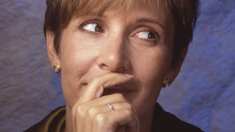 Carrie Fisher smiling behind hand